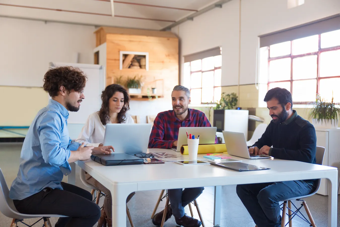 Team around a laptop, bright modern office